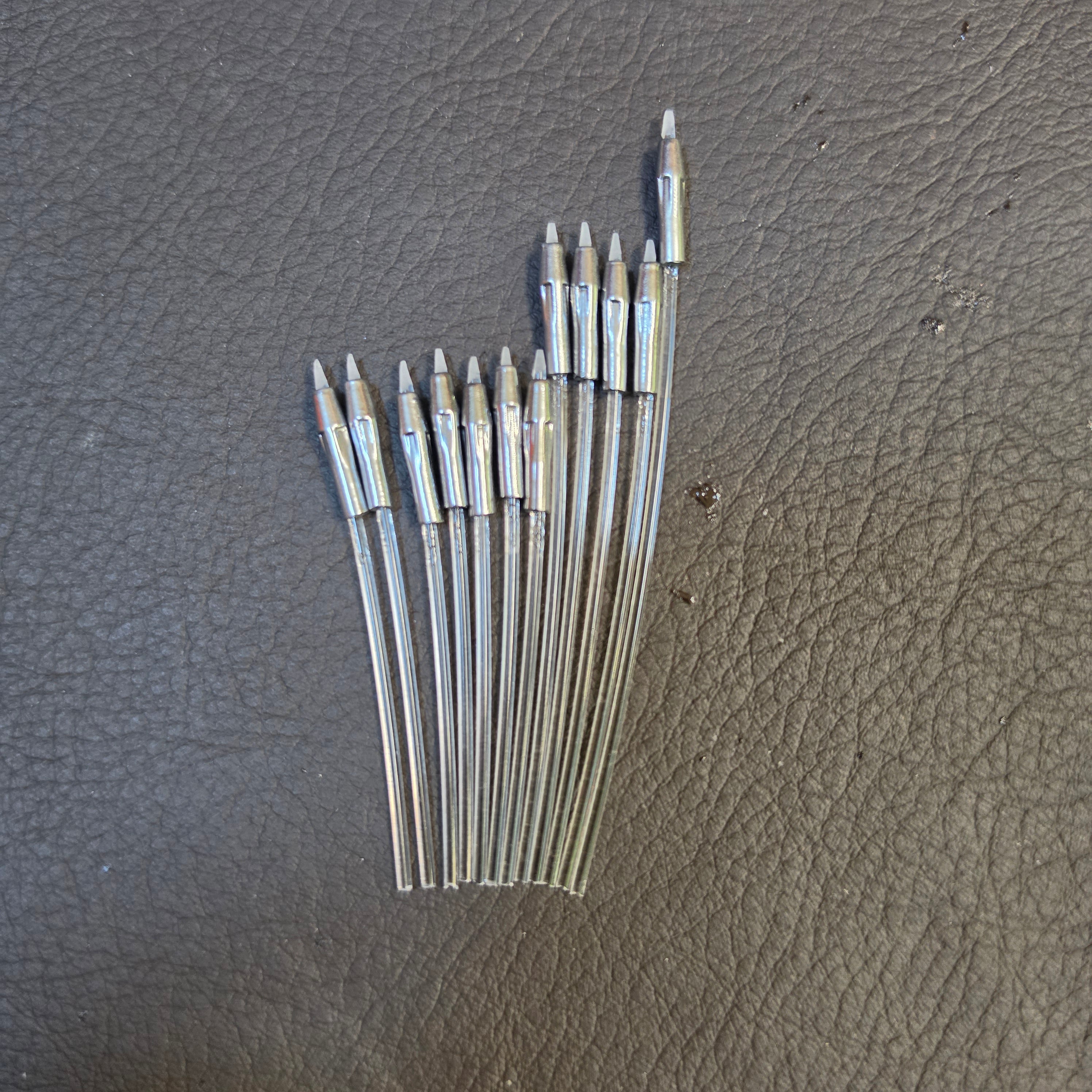 Twelve Alumaluster-finished beskar dart tips fanned loose