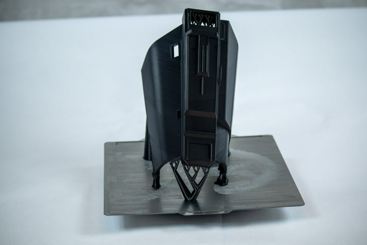 A vertically printed gauntlet part with supports on the print bed