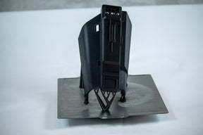 A vertically printed gauntlet part with supports on the print bed