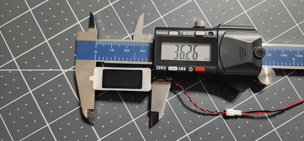 Digital caliper measuring the box speaker length at 36 mm, JST plug beside it