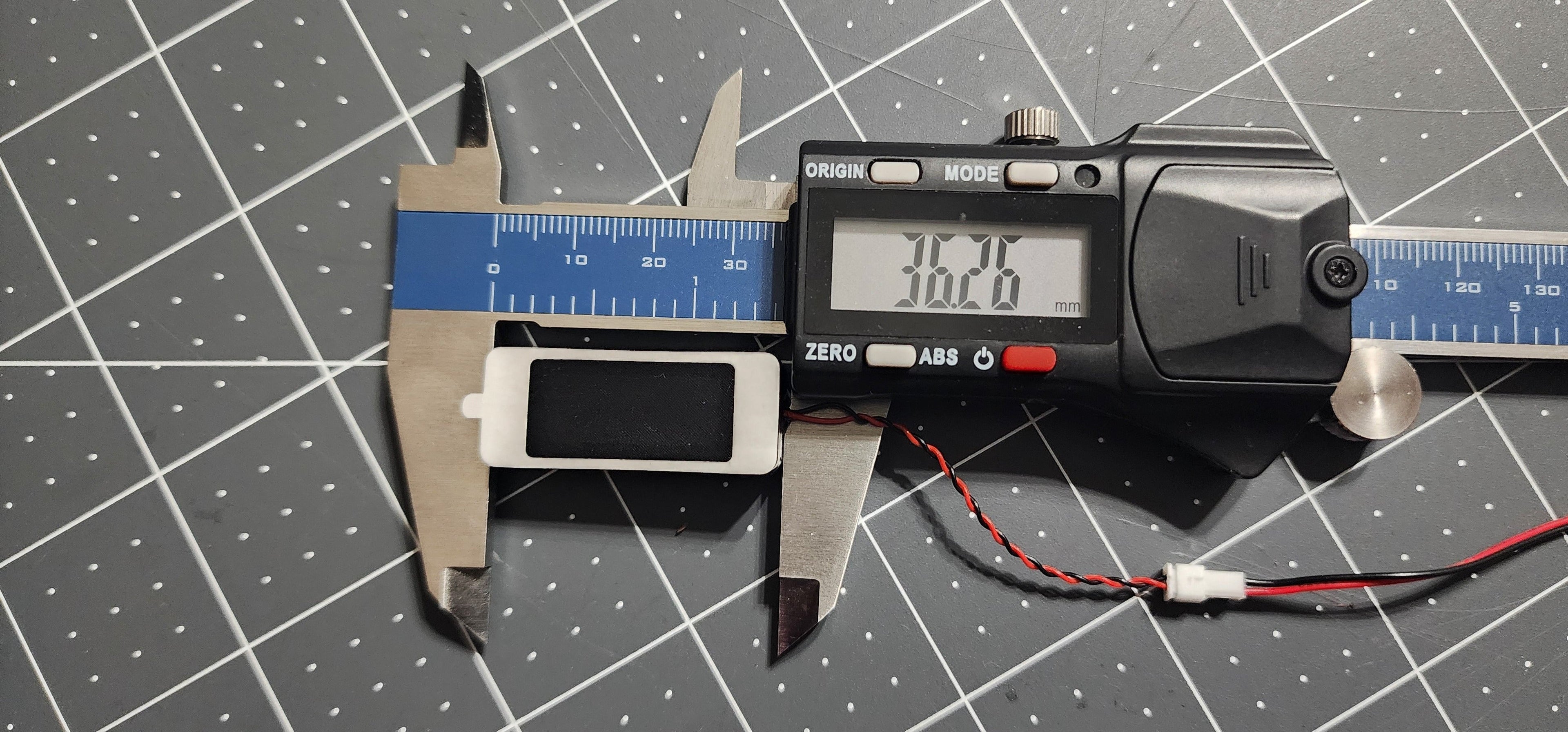 Digital caliper measuring the box speaker length at 36 mm, JST plug beside it