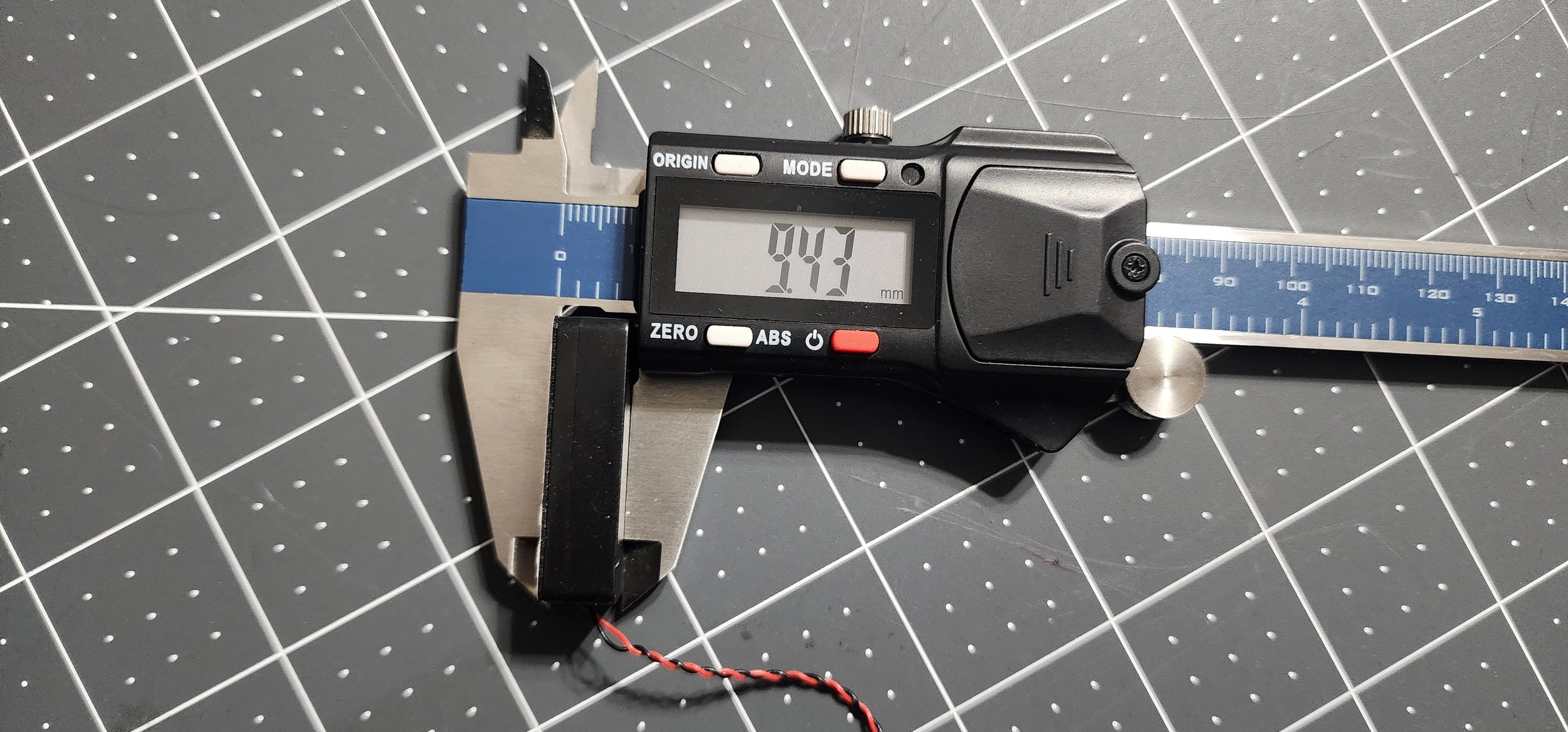 Digital caliper measuring the box speaker depth at 9 mm