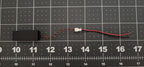 Micro box speaker on a ruled cutting mat showing lead length, JST connector, and included pigtail with bare leads