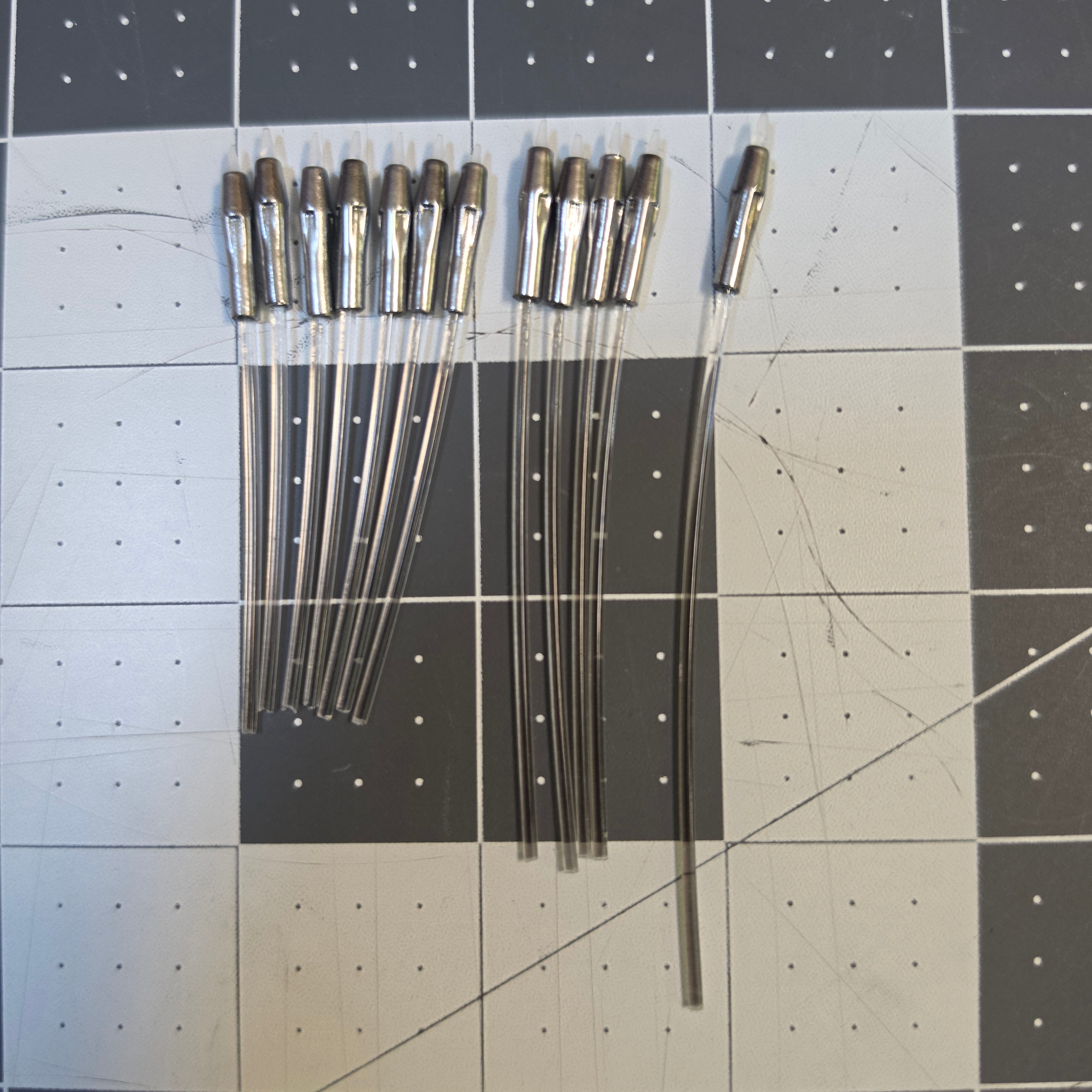 Twelve Alumaluster-finished beskar dart tips with fiber optics fitted